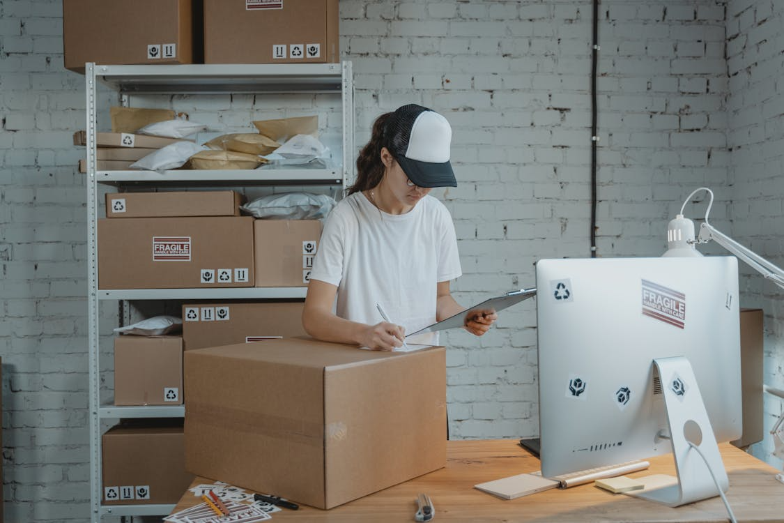 person packing and labeling products in a home shipping station, illustrating high-margin micro businesses