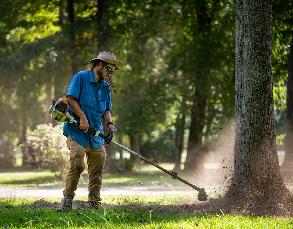 Landscaping worker trimming grass to illustrate local side hustles that generate income